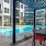 swimming pool in a courtyard with tables and lounge chairs