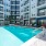 swimming pool in a courtyard with tables and lounge chairs